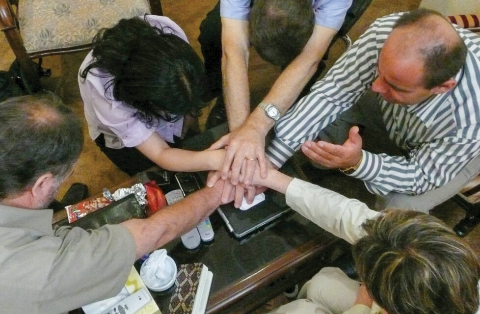 A group of people sit together and pray