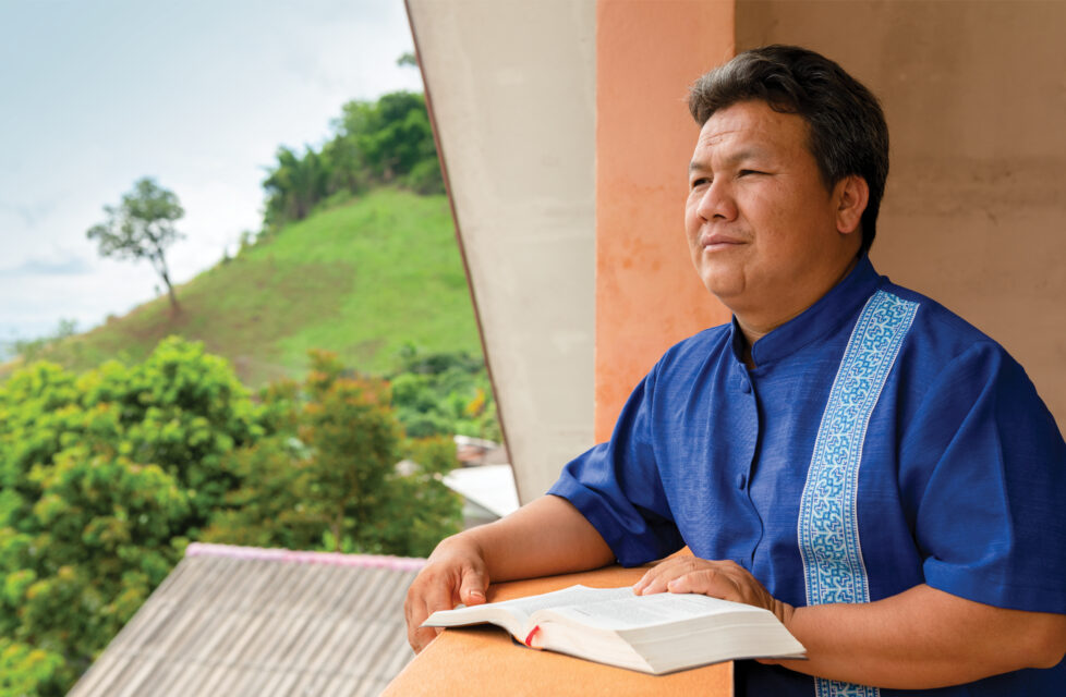 A man sitting on his porch reading the Bible