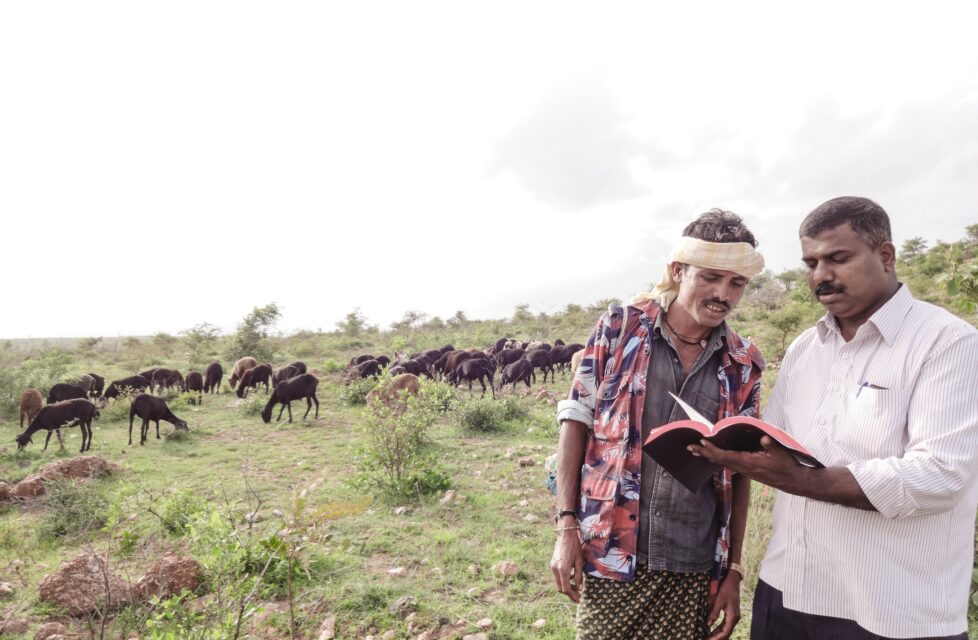 Chandrashekar sharing the gospel with another man and reading him the bible