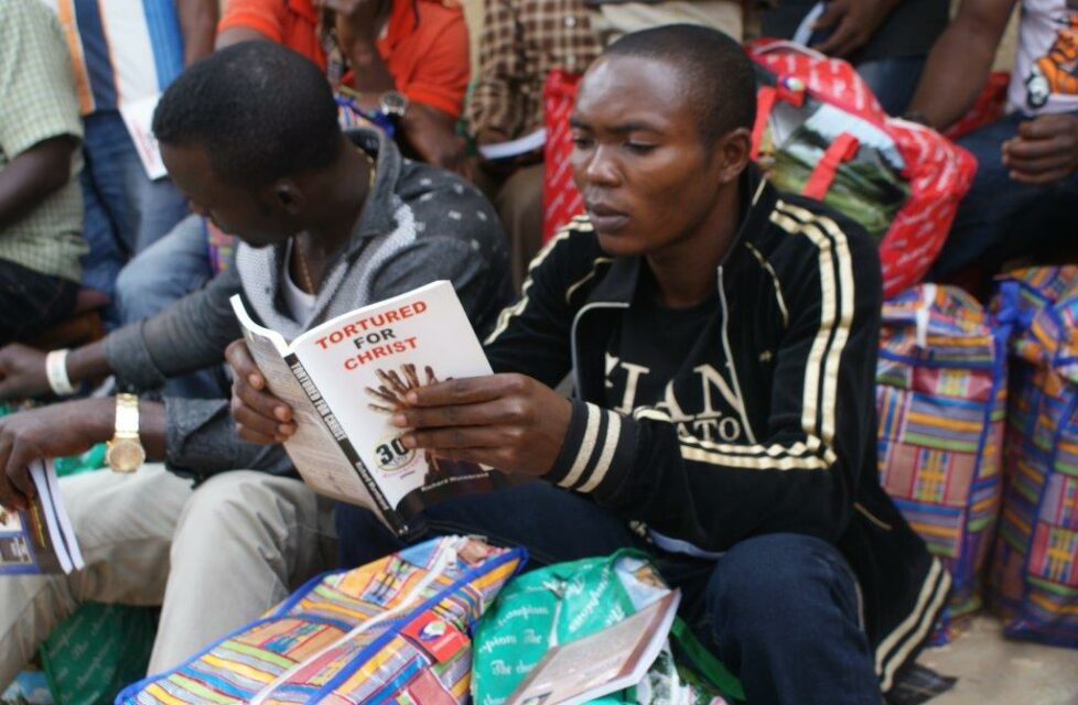 a man sits outside and reads his bible