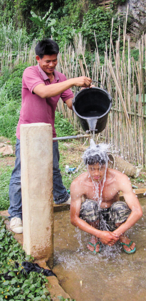 Man pouring water over another mans head 