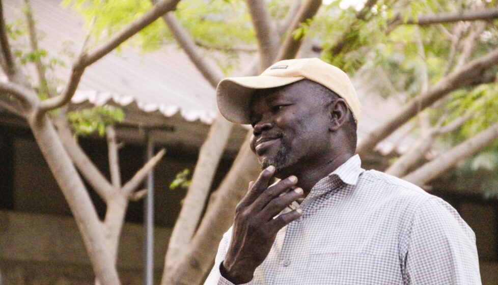 a man stands outside his home smiling